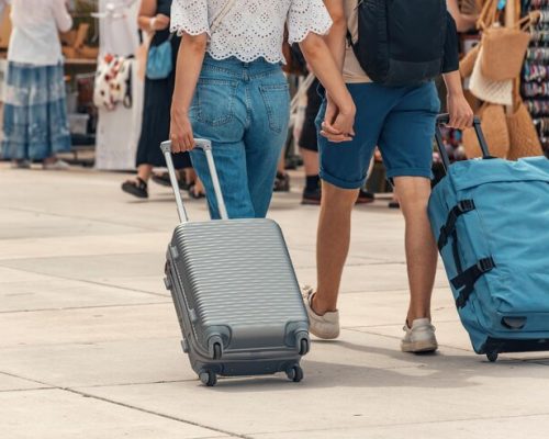 two-travelers-man-woman-walking-with-their-luggage-tow-holding-hands-street_1048944-5113480 two-travelers-man-woman-walking-with-their-luggage-tow-holding-hands-street_1048944-5113480